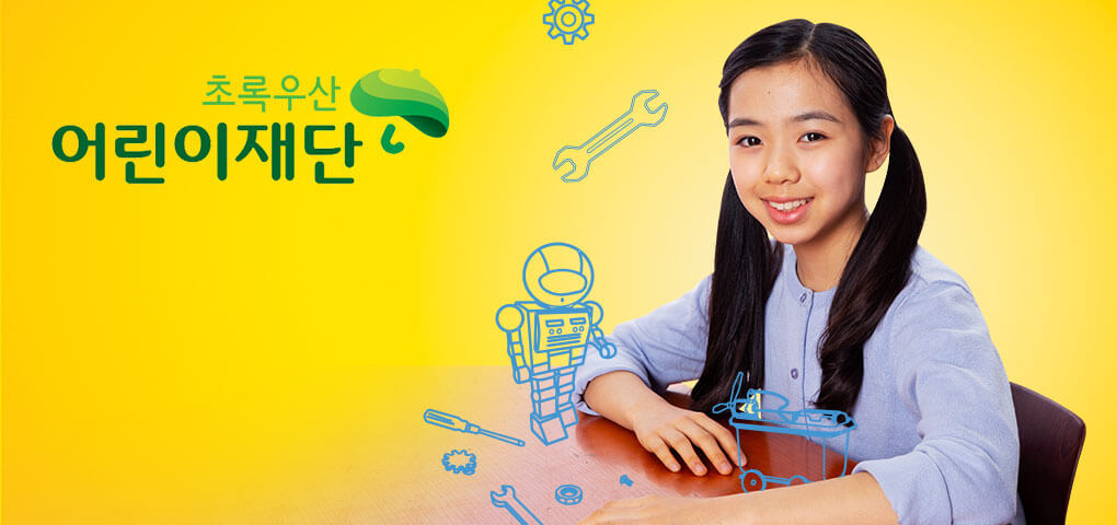 Una niña sentada en un pupitre de la escuela con dibujos fantasiosos de un robot y herramientas. Esta imagen tiene el logotipo de Green Umbrella Children's Foundation.